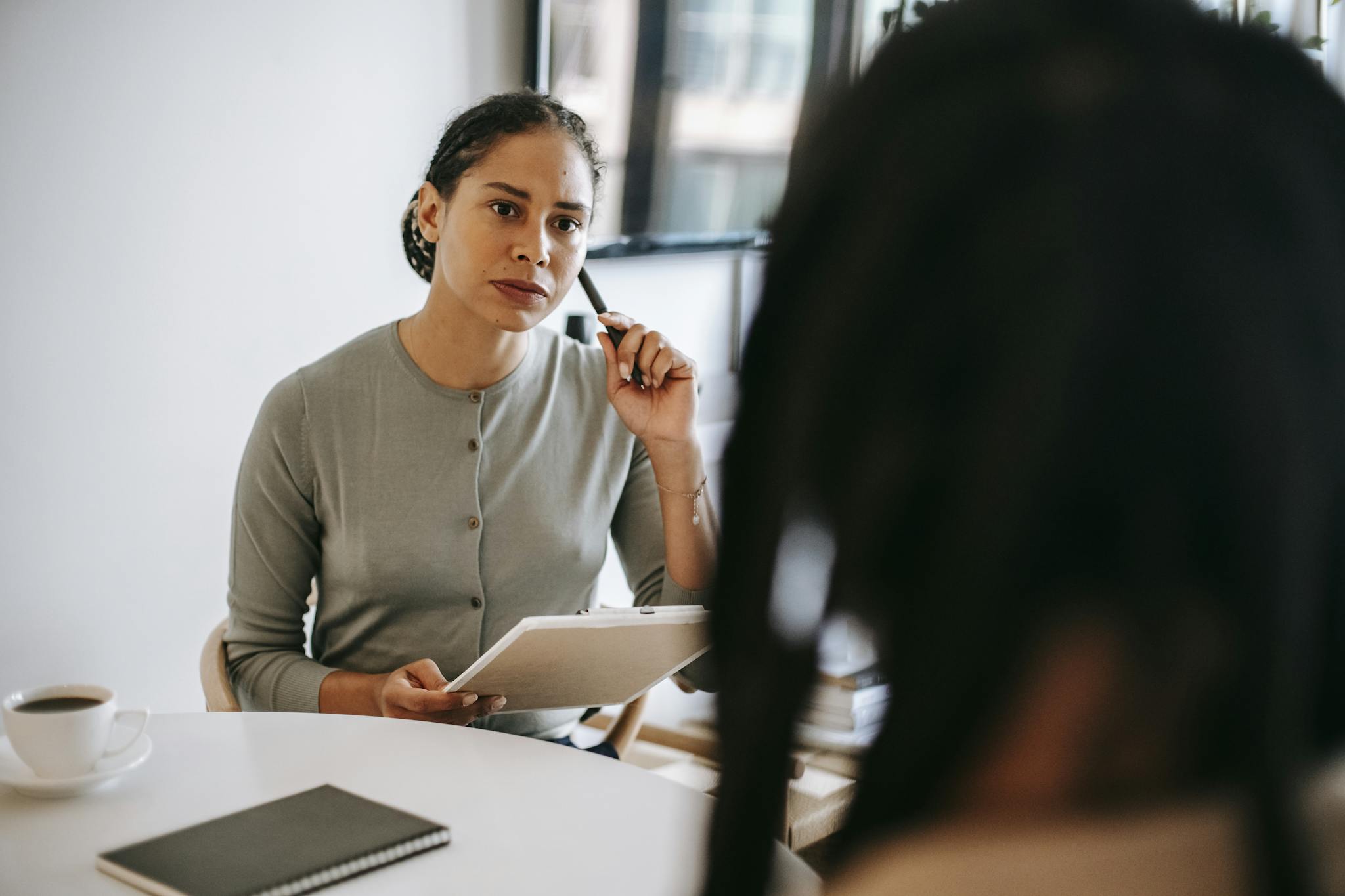 Therapist discussing with a client in a modern office setting. Focus on mental health support.